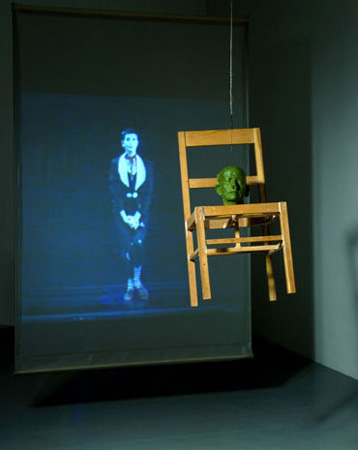 142_B_Neuman_Chit_in_your_hat_head_on_a_chair_1990